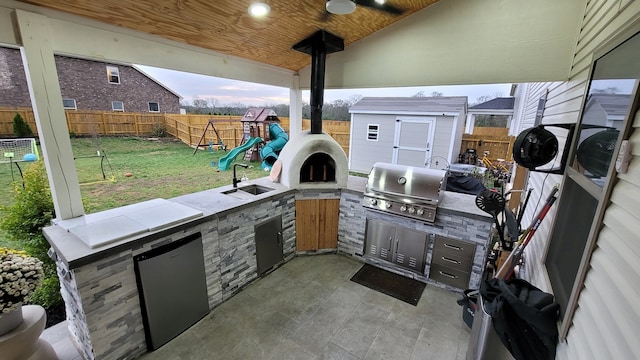 view of patio / terrace featuring a playground, grilling area, area for grilling, and sink