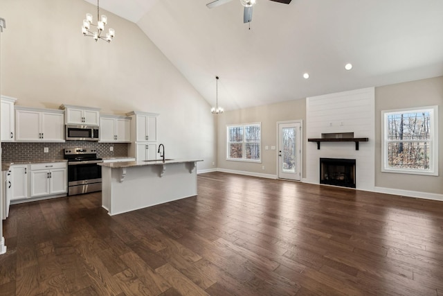 kitchen featuring stainless steel appliances, dark hardwood / wood-style flooring, decorative light fixtures, a breakfast bar, and white cabinets