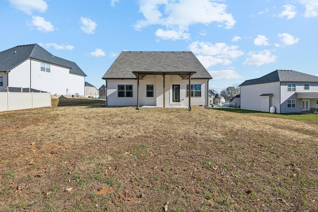 rear view of house featuring a yard