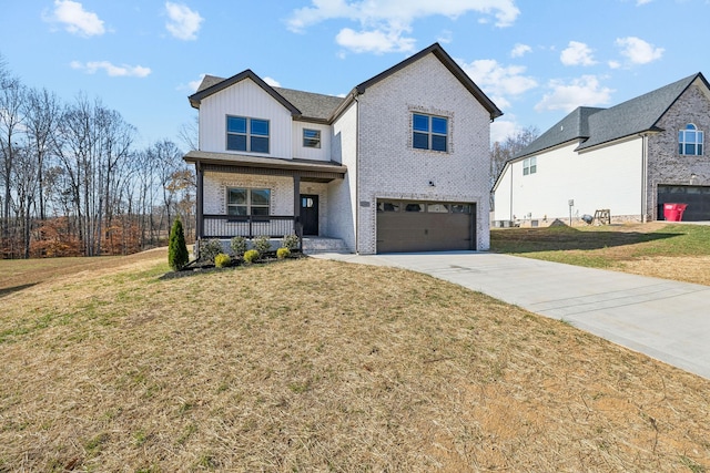 view of front of house featuring covered porch, a front yard, and a garage