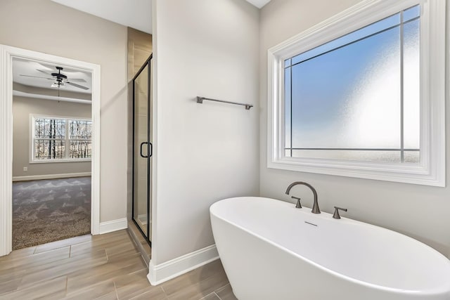 bathroom with hardwood / wood-style flooring, separate shower and tub, and ceiling fan