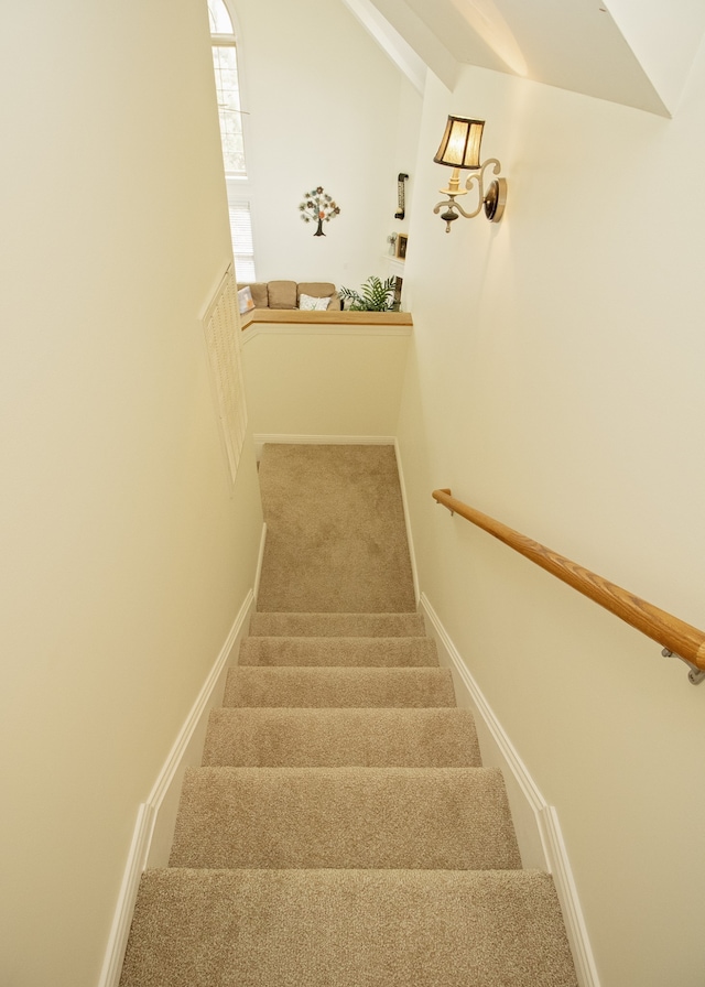 stairs featuring carpet flooring and vaulted ceiling with beams