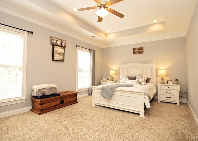 bedroom featuring light colored carpet, ceiling fan, and a tray ceiling