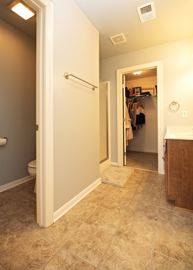 bathroom featuring vanity, toilet, and walk in shower