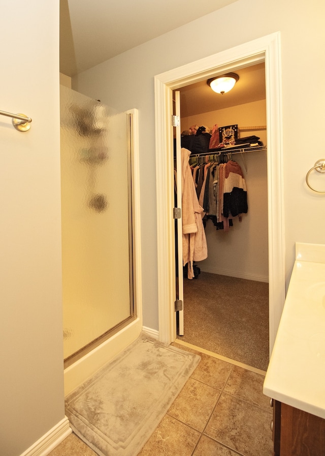 bathroom featuring tile patterned flooring, vanity, and walk in shower