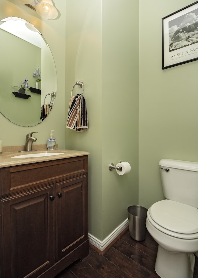 bathroom featuring vanity, hardwood / wood-style flooring, and toilet