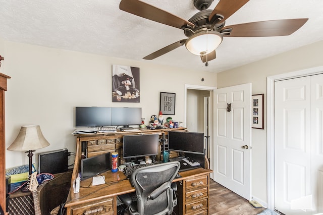 home office featuring a textured ceiling, wood-type flooring, and ceiling fan