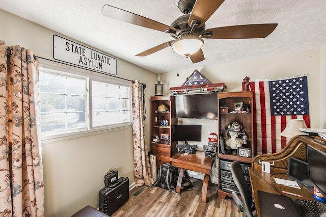 home office with a textured ceiling, hardwood / wood-style floors, and ceiling fan