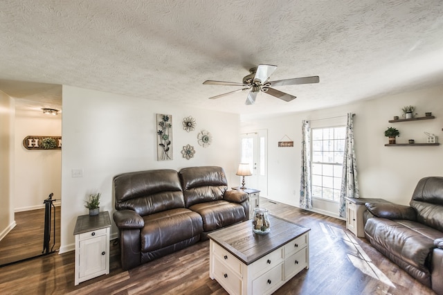 living room with ceiling fan, a textured ceiling, and dark hardwood / wood-style flooring