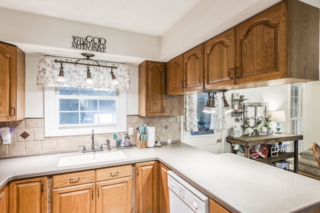 kitchen featuring dishwasher, decorative backsplash, kitchen peninsula, and sink