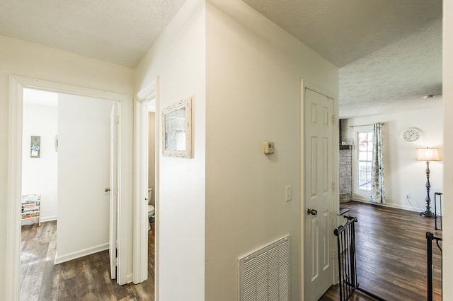 hallway featuring a textured ceiling and dark hardwood / wood-style floors