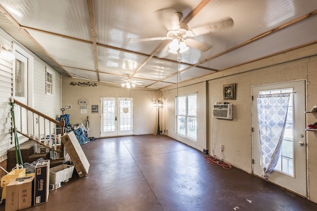 foyer featuring french doors, a wall mounted air conditioner, ceiling fan, and plenty of natural light