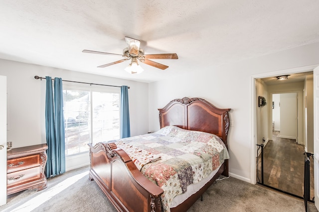 carpeted bedroom featuring a textured ceiling and ceiling fan