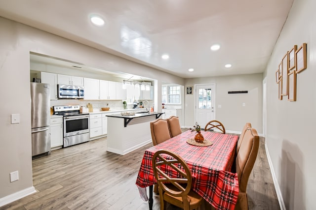 dining area with sink and light hardwood / wood-style flooring