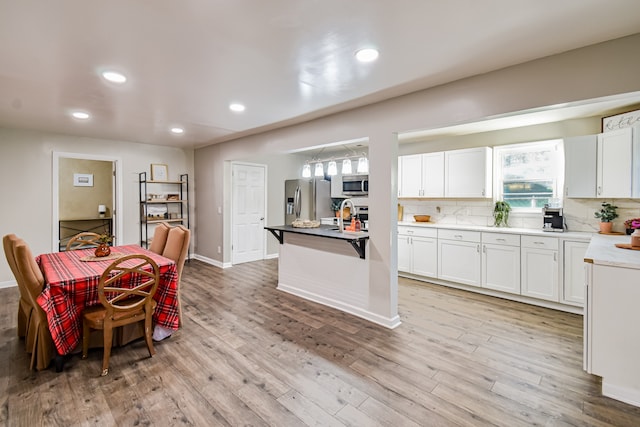 kitchen with white cabinetry, plenty of natural light, light hardwood / wood-style flooring, and appliances with stainless steel finishes