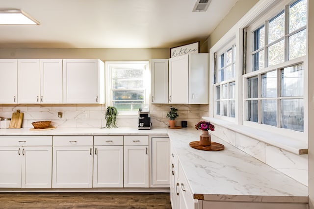 kitchen with white cabinetry, decorative backsplash, plenty of natural light, and dark hardwood / wood-style floors