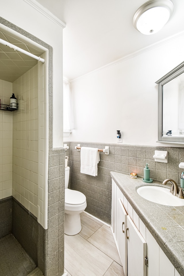 bathroom featuring toilet, vanity, tile walls, and crown molding