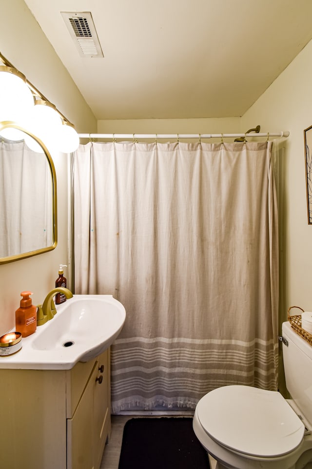 bathroom featuring a shower with curtain, vanity, and toilet