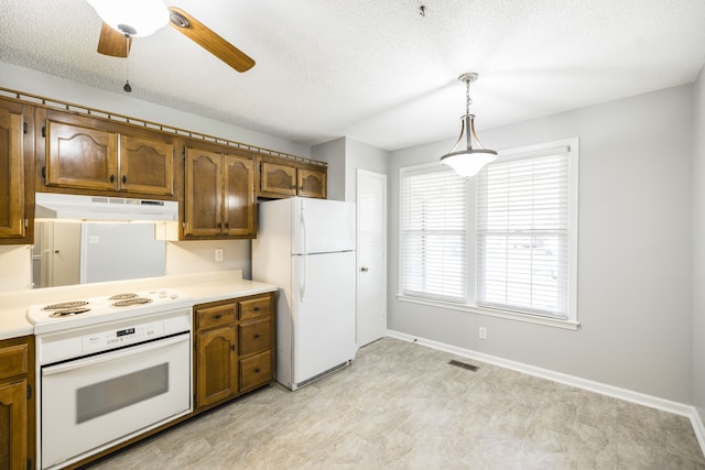 kitchen with a textured ceiling, decorative light fixtures, ceiling fan, and white appliances