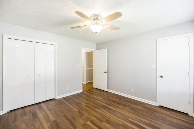 unfurnished bedroom with a textured ceiling, dark hardwood / wood-style flooring, ceiling fan, and a closet