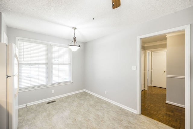 empty room with ceiling fan, a textured ceiling, and light parquet flooring