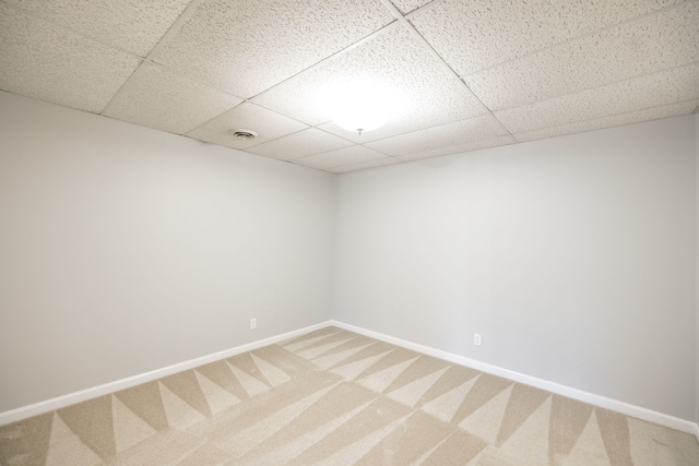 spare room with a drop ceiling and carpet flooring