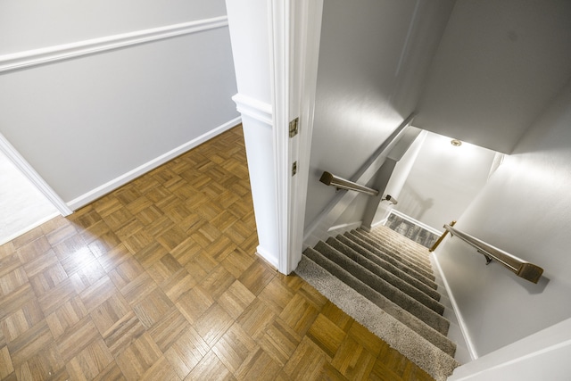 staircase featuring parquet floors