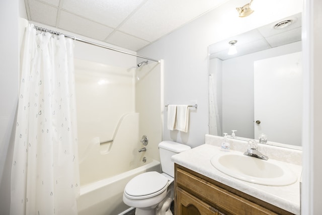 full bathroom featuring vanity, shower / bath combo with shower curtain, a paneled ceiling, and toilet