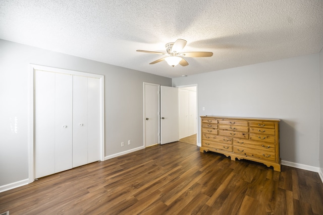 unfurnished bedroom featuring a textured ceiling, dark hardwood / wood-style flooring, and ceiling fan