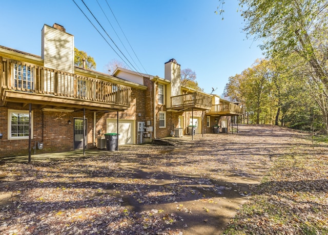 back of house featuring a wooden deck and central AC