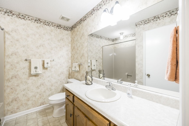 bathroom featuring a shower, vanity, and toilet