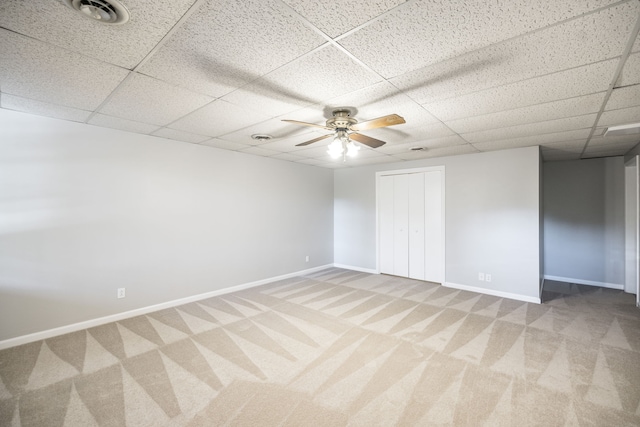 unfurnished bedroom featuring carpet, a drop ceiling, and ceiling fan