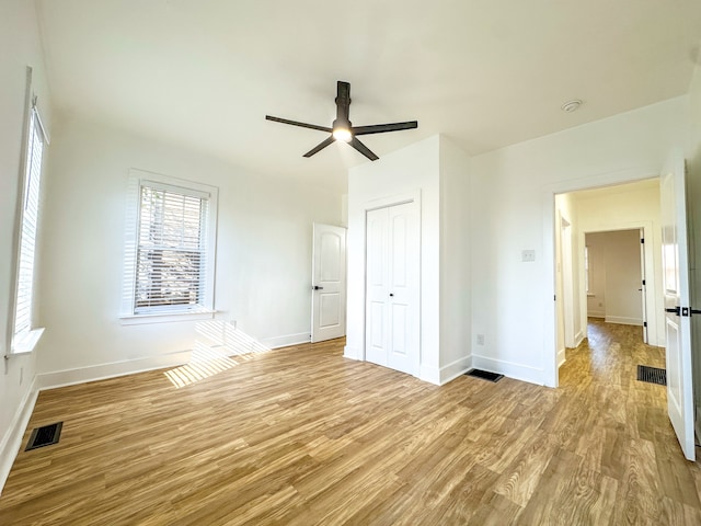 unfurnished bedroom with ceiling fan, a closet, and light hardwood / wood-style flooring