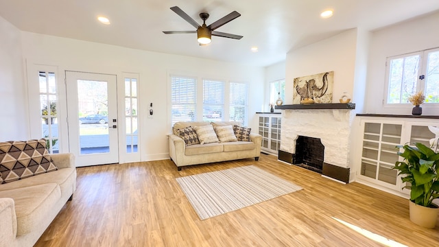 living room featuring a fireplace, hardwood / wood-style flooring, and ceiling fan