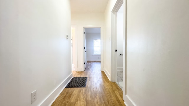 corridor with light hardwood / wood-style floors