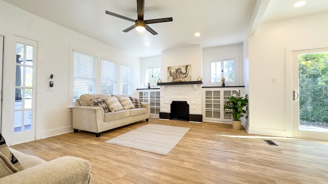 living room featuring a fireplace, hardwood / wood-style flooring, and ceiling fan