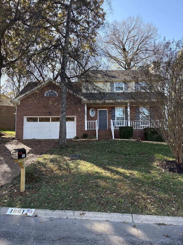 view of front facade with a garage, a front yard, and covered porch