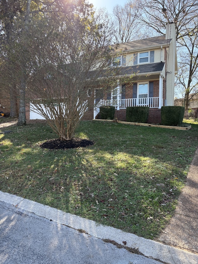 view of front of house featuring covered porch and a front yard