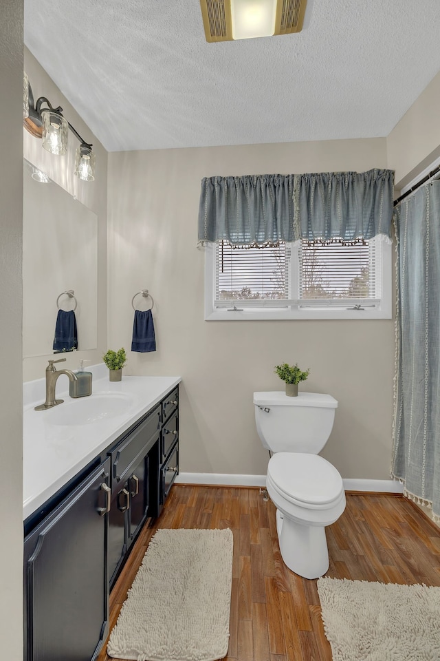 bathroom featuring a textured ceiling, vanity, hardwood / wood-style floors, and plenty of natural light