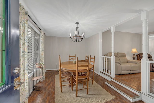 dining space featuring dark wood-type flooring, decorative columns, and a chandelier