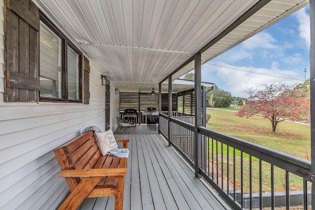 wooden terrace featuring a lawn