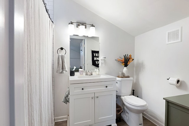 bathroom with hardwood / wood-style floors, vanity, and toilet