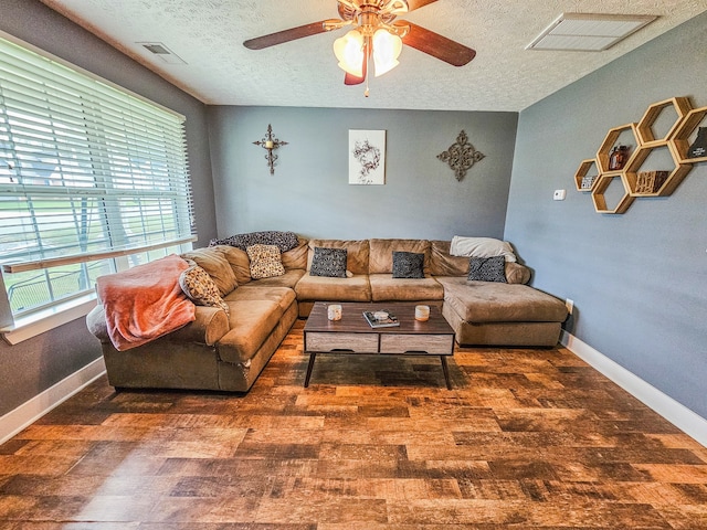 living room with dark wood-type flooring, a textured ceiling, and ceiling fan