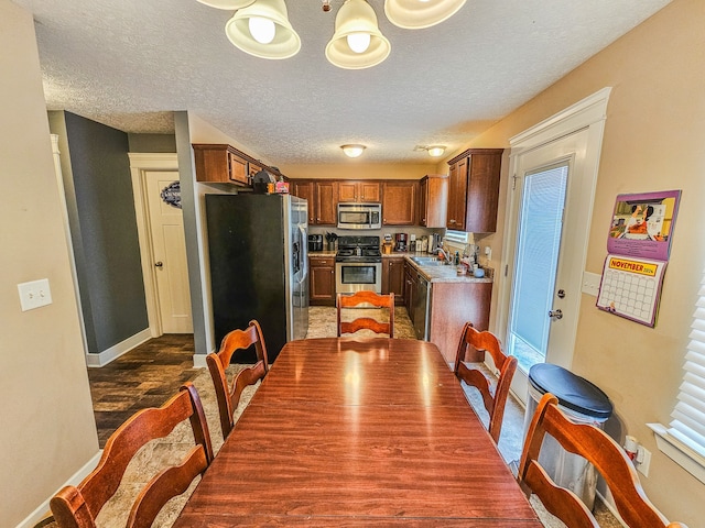 dining area featuring plenty of natural light, sink, and a textured ceiling