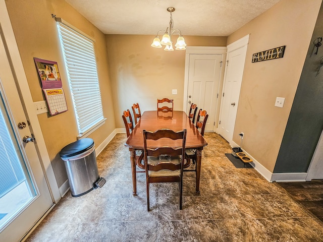 dining area featuring a textured ceiling and a notable chandelier