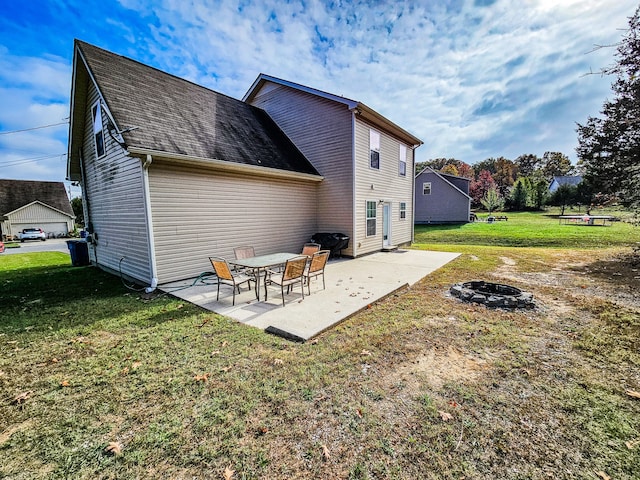 back of property with an outdoor fire pit, a patio, and a yard