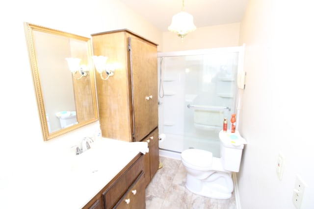 bathroom with vanity, toilet, and a shower with door