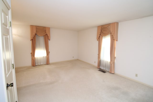 unfurnished room featuring light carpet