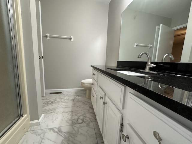 bathroom with vanity, toilet, and an enclosed shower