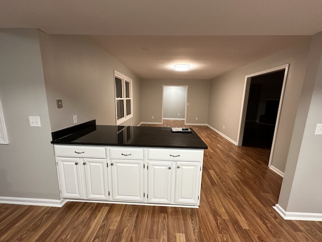 kitchen with dark hardwood / wood-style flooring and white cabinets